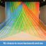 A photo of a site-specific art installation made of linear strands of multi-colored flagging tape arranged in planes that intersect each other in space terminating at a 17 foot long pedestal.