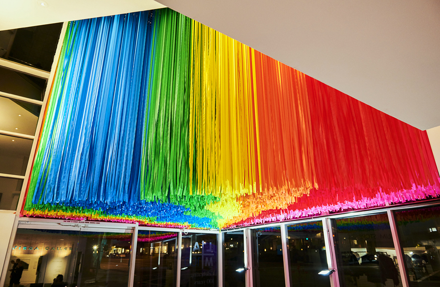 A rainbow-hued, large-scale installation at the Laguna Art Museum in Laguna Beach, California that is suspended from the ceiling, comprised of colorful flagging tape in 6 colors.