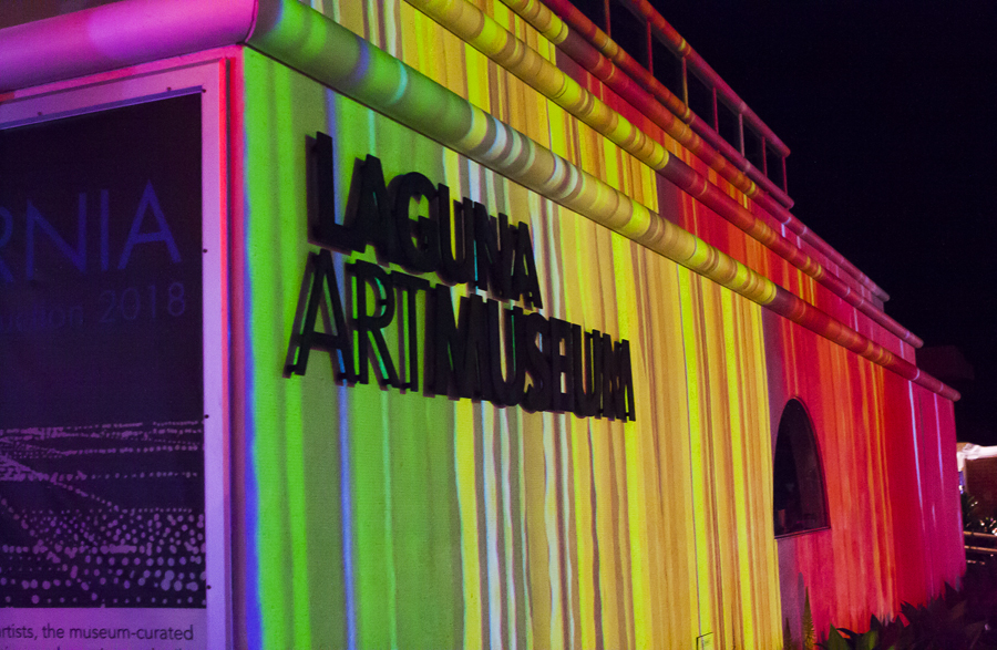 A hyper-colorful, digital projection of Megan Geckler's artwork on the façade of the Laguna Art Museum.